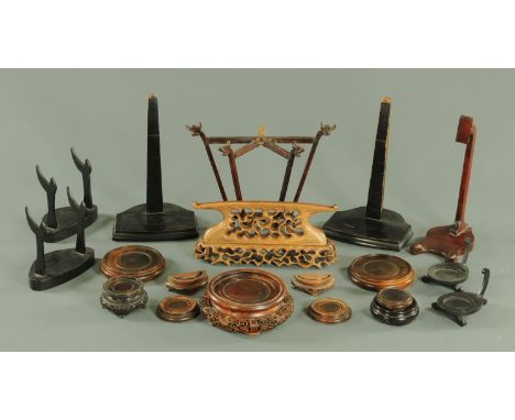 A collection of Oriental carved hardwood stands, for plates and vases, to include a stand for a jade plaque with fretwork dec