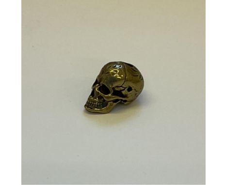 A very well detailed miniature polished bronze ‘Memento Mori’ skull, 23mm.
