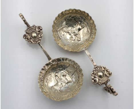 A pair of Continental white metal wine taster / caddy spoons, indistinct marks, the bowls embossed with horse and rider, the 