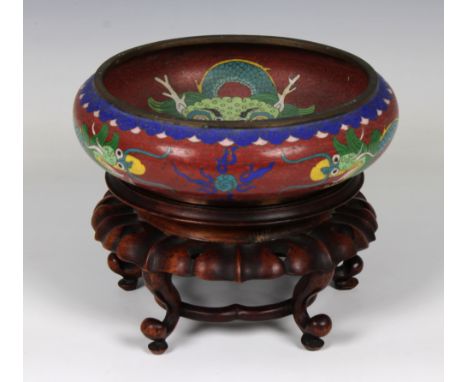 An early 20th century Chinese cloisonne enamel dragon bowl, four character seal mark beneath, on a carved wooden stand, bowl 