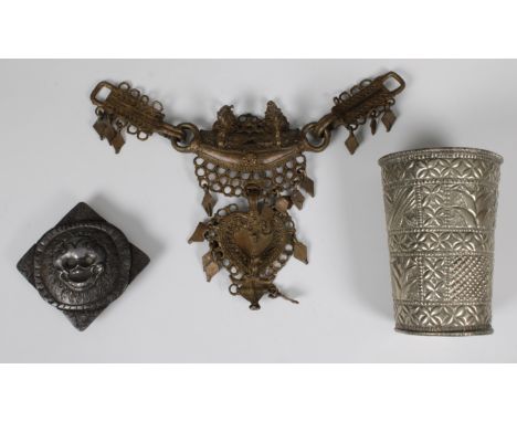 A Tibet Nepal cold iron ferocious skull talisman belt buckle, 10 x 10cm. together with an Indonesian brass tribal necklace 20