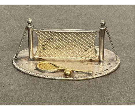 A silver &amp; parcel gilt novelty place card holder in the form of a tennis net, rackets and balls, maker's mark PLG, London