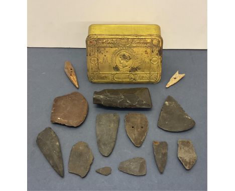 A collection of various Neolithic and later stone implements, arrow and axeheads, etc, housed in a WWI Princess Mary tin. (Qt