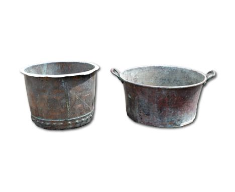 A large copper twin handled basin, 60cm. handle to handle, together with another. (2)