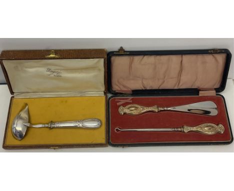 A cased French white metal brandy warming spoon, together with a cased shoe horn and button hook with silver handles. (2)