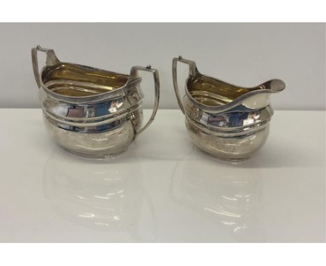 An Edwardian silver sugar basin and milk jug, C S Harris &amp; Sons Ltd, London, 1906, of typical oval boat form, basin 17cm.
