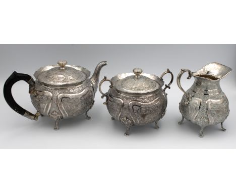 A Persian / Middle Eastern white metal three piece tea service, comprising of teapot, twin handle covered sugar basin, milk j