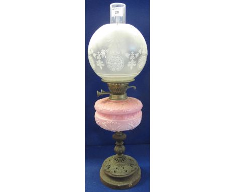 Late 19th Century brass double burner oil lamp with repousse pink glass reservoir on pierced metal pedestal base, having fros