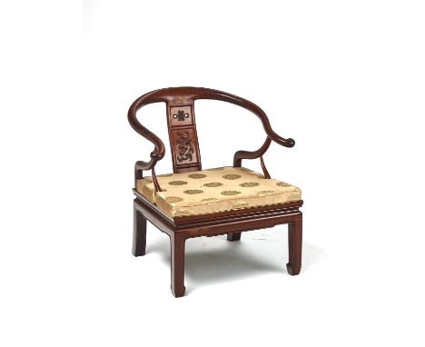 A CHINESE 'HORSESHOE' LOW CHAIR, LATE QING DYNASTYChina, late 19th - early 20th century. Carved from hardwood, possibly Huang