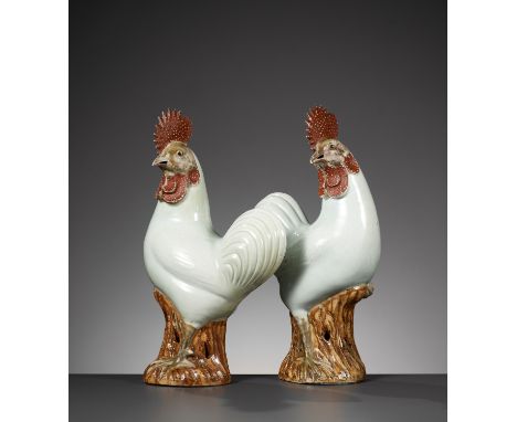 A PAIR OF CHINESE COCKERELS, LATE QING DYNASTYChina, 19th century. Each perched on rockwork bases, the head turned slightly t