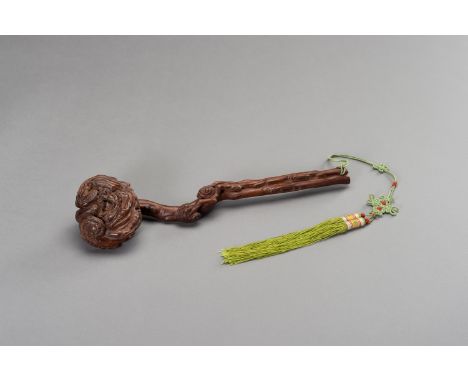 A HARDWOOD RUYI SCEPTERChina, late Qing dynasty (1644-1912), 19th century. The scepter is naturalistically carved as a gnarle