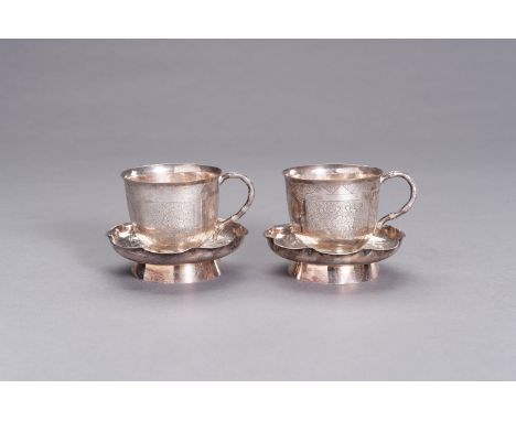 A PAIR OF SILVER CUPS WITH MATCHING SAUCERSChina, c. 1920. Comprising two cups applied with a bamboo-shaped handle and engrav