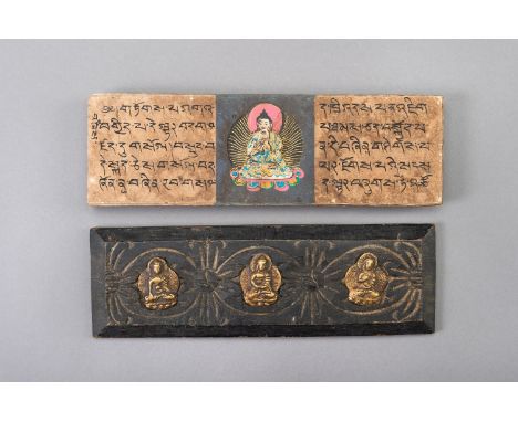 A TIBETAN PRAYER BOOKTibet, 20th century. Consisting of two wooden covers set with three brass reliefs of Buddha, a double va