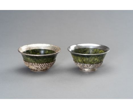 A PAIR OF SILVER MOUNTED SPINACH-GREEN JADE BOWLSTibet, late 19th century. Each with rounded sides rising to a slightly evert