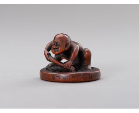 HOKEI: A BOXWOOD NETSUKE OF A MAN FIXING A WHEELBy Hokei, signed Hokei Japan, Edo period (1615-1868)The boxwood netsuke depic