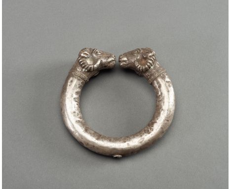 AN ACHAEMENID SILVER RAM-HEADED BRACELETAncient Persia, c. 5th to 4th century B.C. The large open-ended bracelet with ram hea