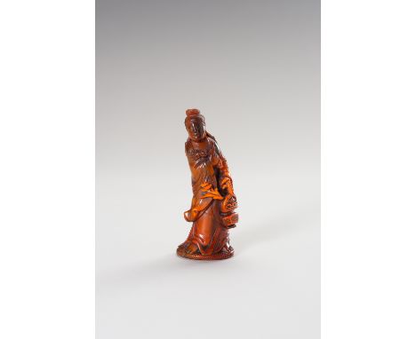 A HORN FIGURE OF GUANYINChina, Qing Dynasty (1644-1912). Guanyin carved leaning towards her right side, dressed in a long rob