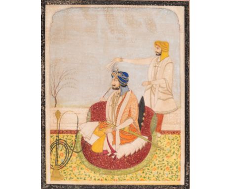 AN INDIAN MINIATURE PAINTING OF A RULER SMOKING A HUQQAIndia, 19th century. Gouache and ink on paper. The prince seated on a 