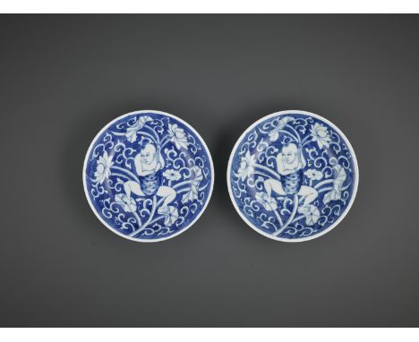 A NEAR-PAIR OF BLUE AND WHITE 'LOTUS BOY' DISHES, KANGXI PERIODChina, 1662-1722. Each with shallow sides rising from a flat f