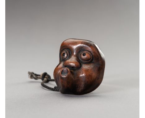 A LARGE HYOTTOKO MASK WOOD NETSUKEJapan, 19th century, Edo period (1615-1868)The large wooden netsuke carved as a hyottoko ma
