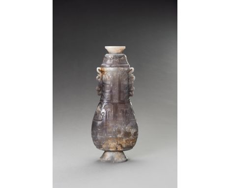 A LILAC-GRAY JADE ARCHAISTIC VASE AND COVER, HU, 20TH CENTURYChina. The flattened pear-shaped body, supported by a spreading 