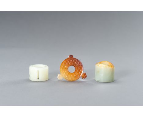 A JADE GROUP COMPRISING TWO ARCHER'S RINGS AND AN ARCHAISTIC BI DISCChina, late Qing Dynasty (1644-1912) to Republic period (