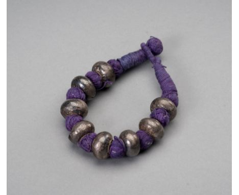 A SILVER BEADED BRACELET, 1900sNepal, late 19th - early 20th century. The tribal bracelet with eight silver beads, interspers