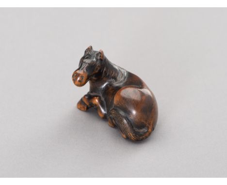 A WOOD NETSUKE OF A RECUMBENT HORSEJapan, Edo period (1615-1868)Carved depicting a reclining horse, with its long legs tucked