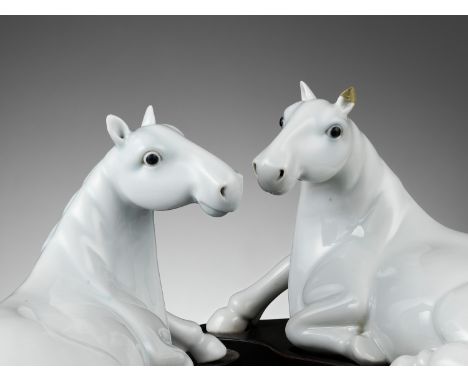 A PAIR OF WHITE-GLAZED FIGURES OF HORSES, QING DYNASTYChina, 19th century. Each modeled in mirror image as a recumbent horse 