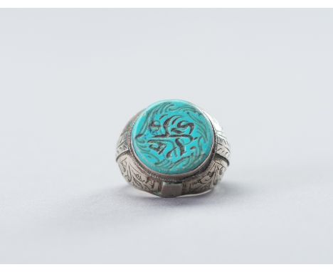 A PERSIAN SILVER RING WITH TURQUOISE MATRIX INTAGLIO, 19TH CENTURYPersia. The ring with a silver setting, with carved leafy d