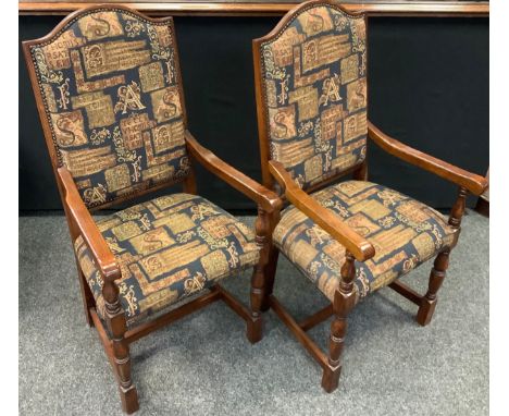 A pair of 21st century oak elbow chairs, the arched back and seats upholstered in Medieval style tapestry, c.2010 