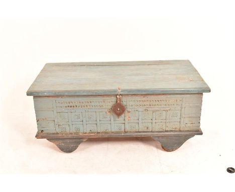 A blue painted metal bound wooden trunk, standing on four shaped feet but with the edition of four trolley wheels for ease of
