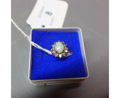 A ladies 18ct white gold ring, having opal to centre surrounded by twelve round cut diamonds