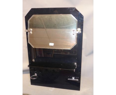 An Art Deco black glass bathroom unit with mirror above shelf, cup holder and toothbrush holder