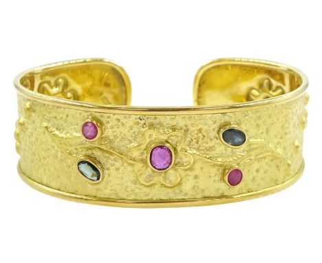 18ct gold sapphire and ruby cuff bangle, with embossed floral decoration, stamped 750Condition Report:Approx 18.6gm, tested 1