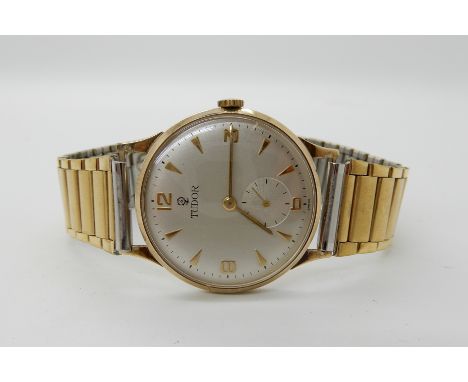 A 9ct gold Tudor watch head, with a gold plated strap, diameter of the dial 3.1gms Condition Report: Available upon request