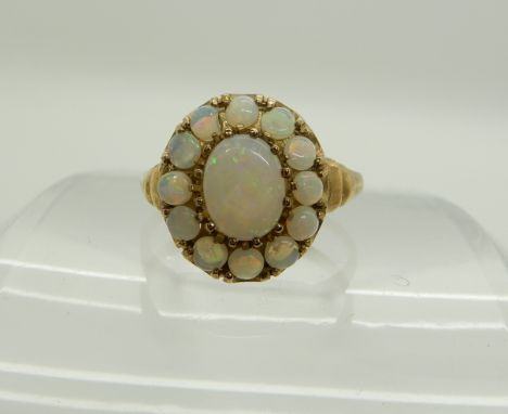 A 9ct gold opal cluster ring, size Q, head size approx 14mm, weight 2.7gms Condition Report: One of the smaller opals is chip