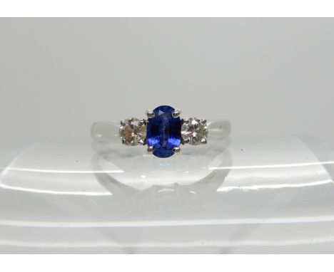 An 18ct white gold sapphire and diamond three stone ring, diamonds estimated approx combined 0.26cts, sapphire approx 6mm x 4