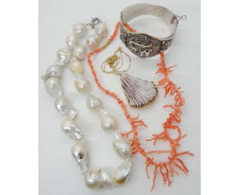 A coral pendant on 18ct gold figaro chain, string of angel skin coral beads, a string of large baroque pearls and a large whi
