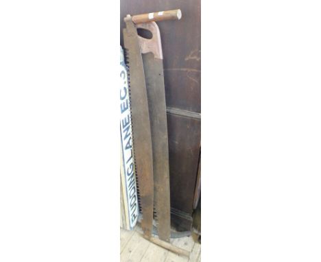 Two vintage saws and a scythe 
