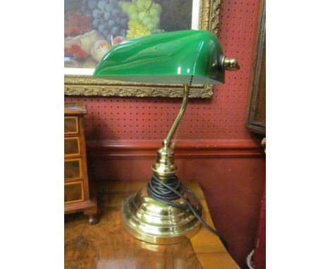 A brass bankers lamp with green glass shade