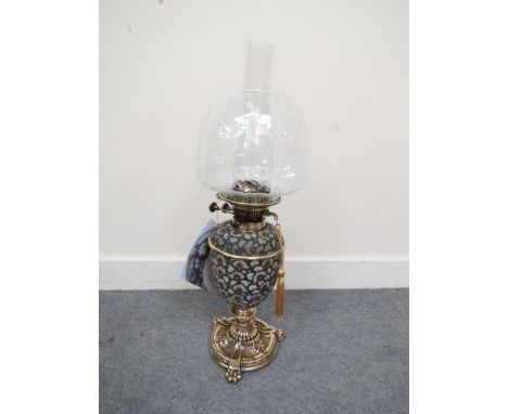 An Edwardian Messenger oil lamp with brass base and lion paw supports, the ceramic body is by MacIntyre and Moorcroft Burslem