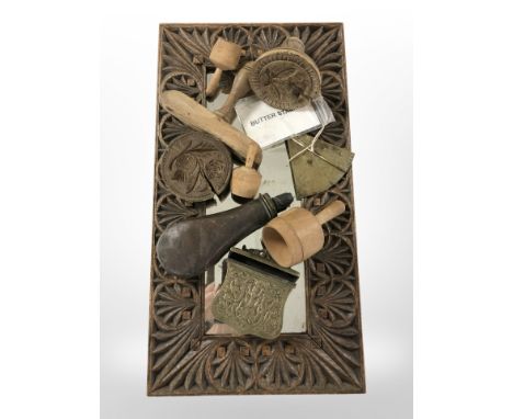 A heavily carved oak mirror, length 55cm, together with a group of wooden butter stamps, brass measuring dial, brass belt pou