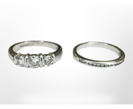 A platinum three-stone brilliant-cut diamond ring, size K/L, 5.5g, together with platinum diamond half eternity ring en-suite