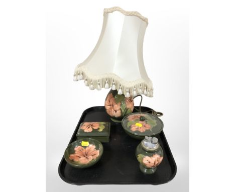 Five pieces of Moorcroft pottery, to include a table lamp, two lidded boxes, a bowl and a table lighter.