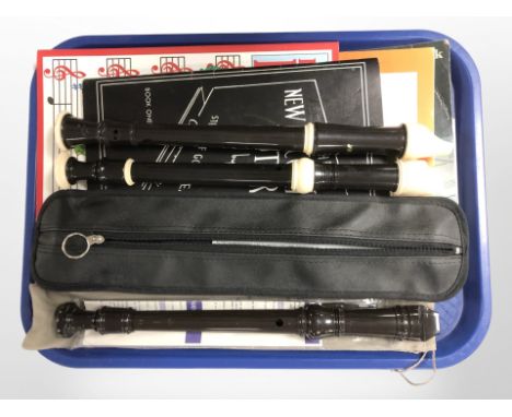 A Yamaha recorder, Dolmetsch recorder and one other, with accompanying sheet music. 