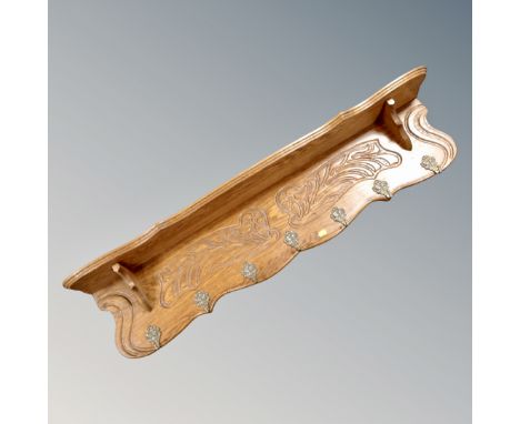 A contemporary oak carved wall shelf with seven metal hooks, length 123cm