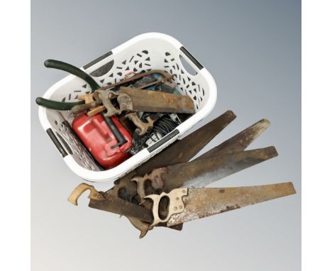 A basket of vintage tools, hand saws, petrol can 