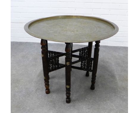 Benares style table, brass circular top on wooden stand with mother of pearl inlaid pattern,  57 x 68cm. 