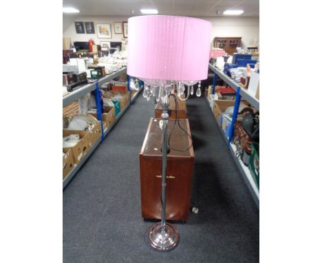A contemporary metal four-way floor lamp with glass drops and pink shade 